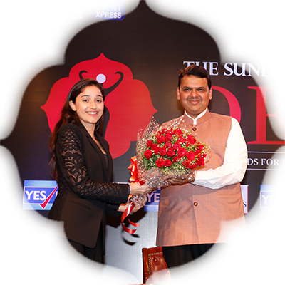 Roshini Kapoor, co-founder of TTS-IO & ED of ART Capital, presents Devendra Fadnavis with flowers