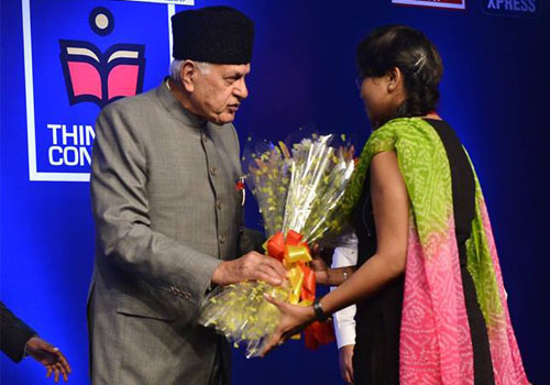 Farooq Abdullah gives the bouquet of flowers to a young student