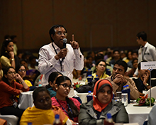 An audience member asks a question during the interaction with the panelists.